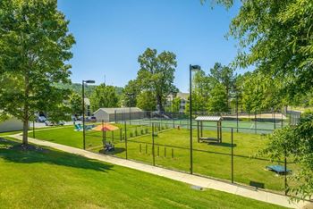 a park with a tennis court and a fence